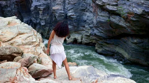 A Graceful Dancer Poses by a Serene River Amidst Majestic Rock Formations Stock Footage 315734467