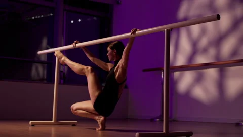 Graceful female dancer performing a contemporary routine using a ballet barre Stock Footage 344908119