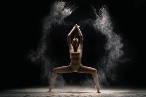 Graceful lady in body stand in split with dust Stock Photos