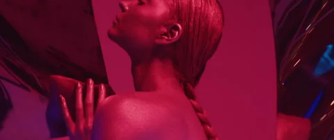 Graceful model poses in studio in bright red neon, emotionally looking at camera Stock Footage 160667141