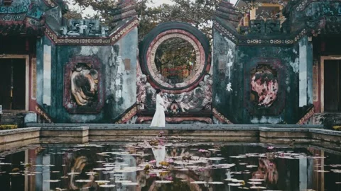Graceful Steps by Ba Mu Temple Gate – A Dreamy Lotus Pond Awaits in Hoi An Stock Footage 303689833