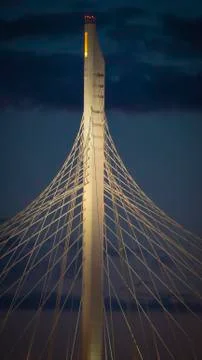 The graceful supports of the cable-stayed bridge in the evening illuminated by Stock Photos