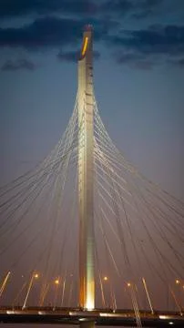 The graceful supports of the cable-stayed bridge in the evening illuminated by Stock Photos