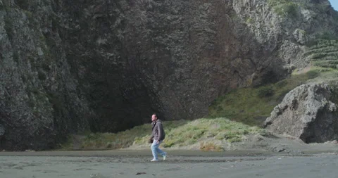 Graded C4K 120fps Man jump spin with cliff in the background Stock Footage 136562937