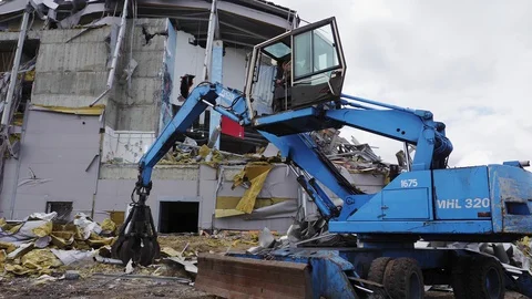 Grader disassembles debris of destroyed hockey stadium Stock Footage 127740672