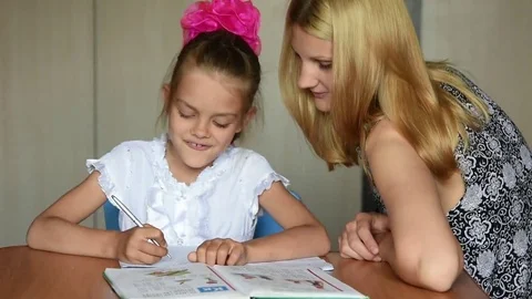 Grader in a good mood makes school lessons with his mother Stock Footage 69084844