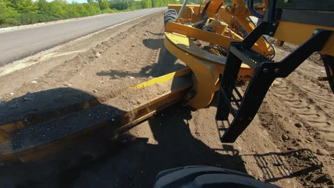 Grader levels ground for construction of new road or highway, blade rake soil Stock Footage 164988767