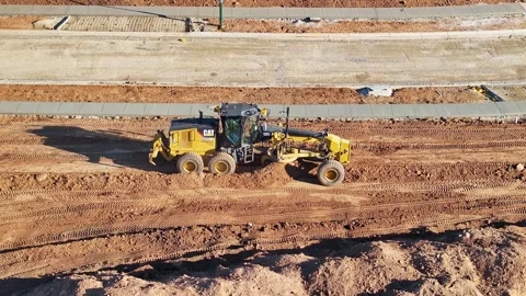 Grader spinning its wheels as it works hard to push a large amount of dirt Stock Footage 278340166