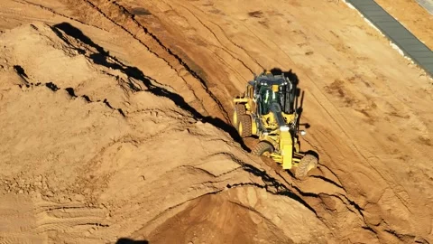Grader working the front wheels hard in deep dirt at a site with front end .. Stock Footage 278340249