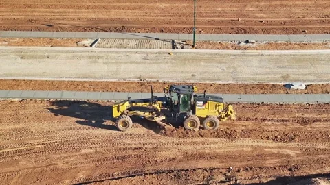 Grader working hard at pushing large quantities of dirt at a construction sit Stock Footage 278340162