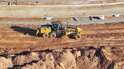 Grader working at a levelling run in heavy dirt at a construction site Stock Footage 278340181