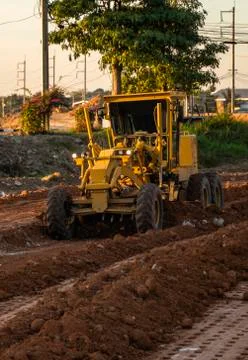 Grader is working on road construction. Grader industrial machine on Stock Photos