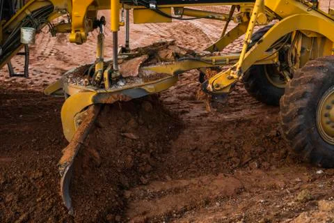 Grader is working on road construction. Grader industrial machine on Stock Photos