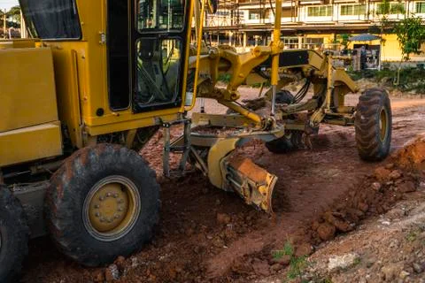 Grader is working on road construction. Grader industrial machine on Stock Photos