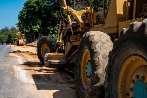 Grader is working on road construction. Grader industrial machine on Stock Photos