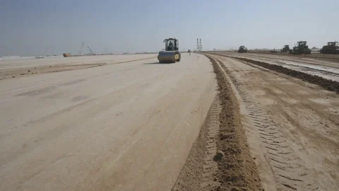 Graders level the road in the desert, preparing for the construction of roads Stock Footage 145556965