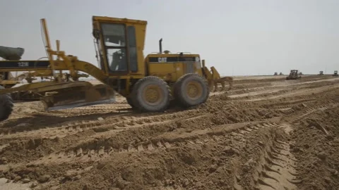 Graders level the road in the desert, preparing for the construction of roads Stock-Footage 145557515