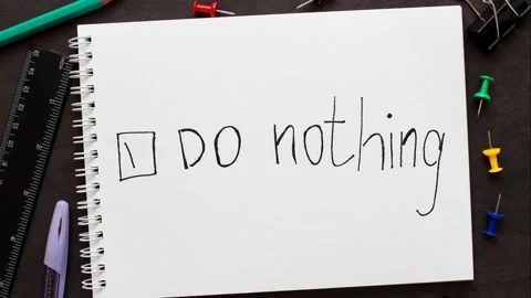 Gradually appearing words "Do nothing" with check mark on a notebook. Stock Footage 155765062