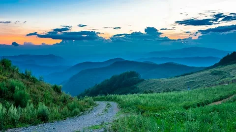 Gradually darker flowing through a mountain ridge above the clouds. Zoom in Video stock 145743651