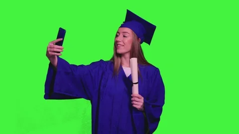 Graduated student taking selfie with graduation certificate on green screen Stock Footage 302401540