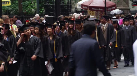Graduates in caps and gowns marching past onlooking crowd Stock Footage 59454582