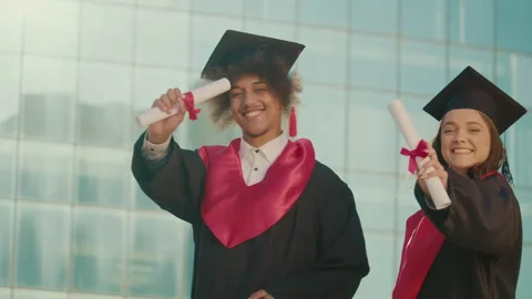 Graduates Showing Diplomas on Camera while Walking on Background of University. Stock Footage 241282285