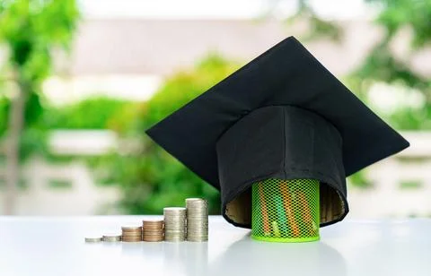 Graduation cap on coin stack on blured background. Stock Photos