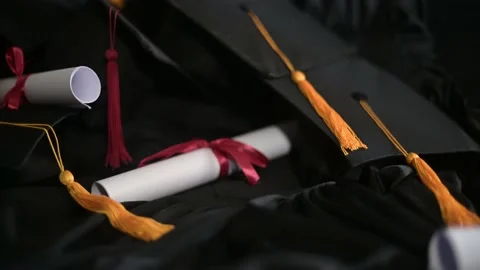 Graduation cap placed on a black academic gown,Education concept Stock Footage 136530398