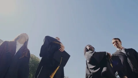 Graduation Celebration with Happy Young Multi-Ethnic Graduates Throwing Caps up Stock Footage