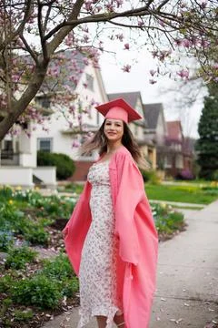 Graduation ceremony in springtime setting with a young woman celebrating in.. 写真素材