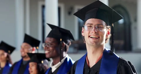 Graduation, face and man on campus with crowd, academic success and pride at Stock Footage 346749145