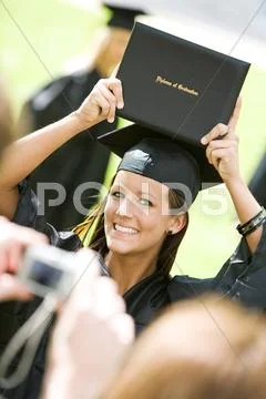 Graduation: girl holds up college diploma for camera Stock Photos