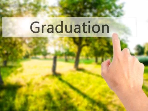 Graduation - Hand pressing a button on blurred background concept on visual s Stock Photos