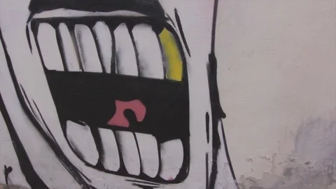 Graffiti of an angry face on a wall Stock Footage 79537675