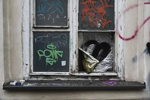Graffiti-covered broken window with duct tape, abandoned Kraków building Stock Photos