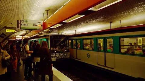 Graffiti covered metro train pulls into crowded subway station Paris Stock Footage 117114630