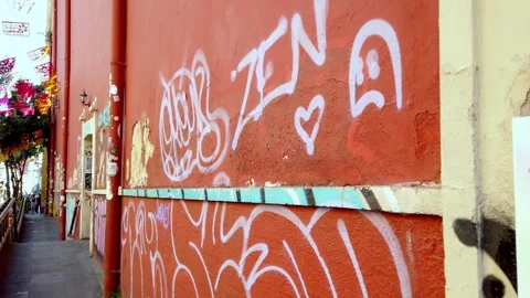 Graffiti-covered orange wall in a narrow urban alley with event poster and Stock Footage 328701584