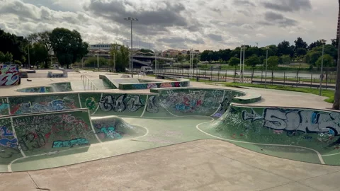 Graffiti-covered walls wrap around the silent skate bowls, colors fading under Stock Footage 327502315