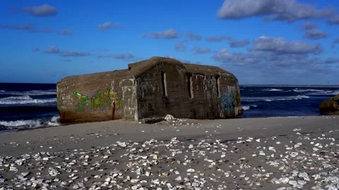 Graffiti-Covered WWII Bunker on Shell-Strewn Beach, Nationalpark Thy, Denmark Stock Footage 336009320