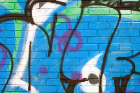 Graffiti patterns cover brick wall Фото