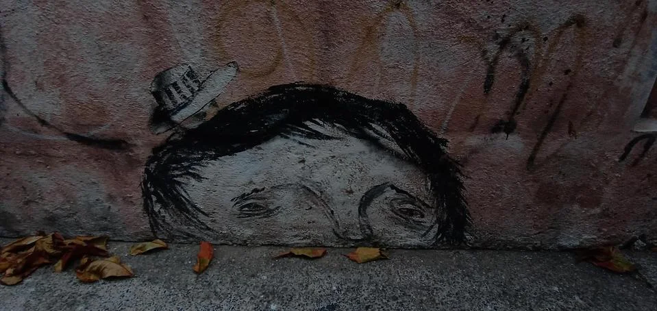 Graffiti of a sad kid with fallen leaves Stock Photos