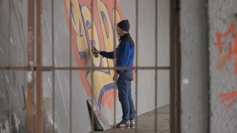 Graffiti. Teens paint on the wall. Stock Footage 83161785