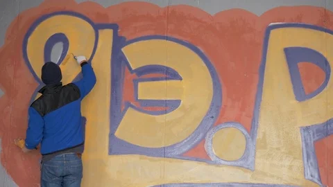 Graffiti. Teens paint on the wall. Stock Footage 83162079