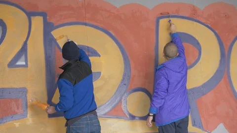 Graffiti. Teens paint on the wall. Stock Footage 83162138