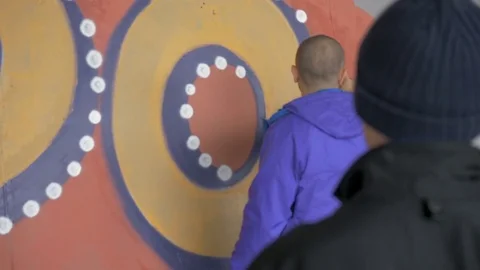 Graffiti. Teens paint on the wall. Stock Footage 83162455