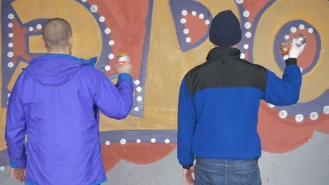 Graffiti. Teens paint on the wall. Stock Footage 83162546