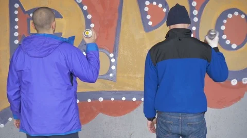Graffiti. Teens paint on the wall. Stock Footage 83162605