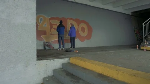 Graffiti. Teens paint on the wall. Stock Footage 83163076