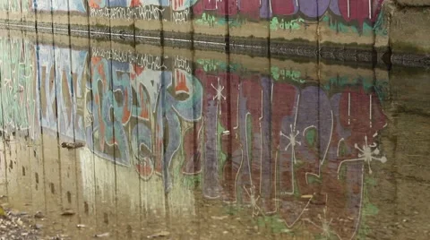 Graffiti wall. Reflection of graffiti in the water. Camera upwards motion. Stock Footage 42680937