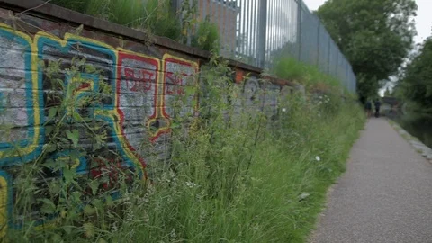 Graffiti wall slow pan across to canal Stock-Footage 115334873
